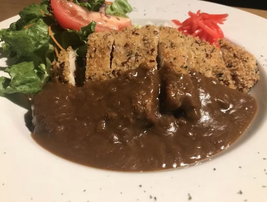 Japanese curry plate with a breaded cutlet, rice, and salad at Mix Pacific Rim
